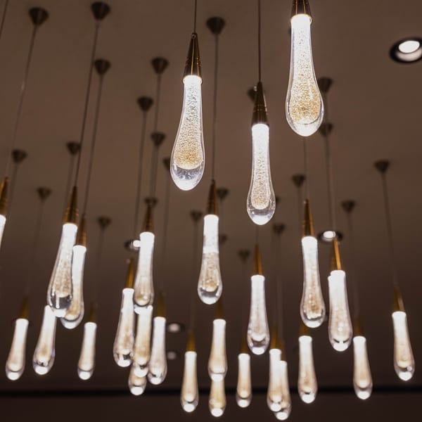 Teardrop-shaped pendant lights with sparkling interiors hang from the ceiling, creating an elegant ambiance.