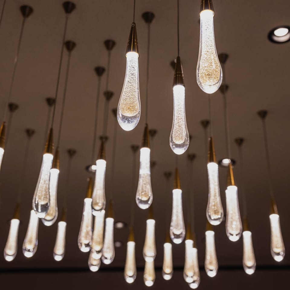 Teardrop-shaped pendant lights with sparkling interiors hang from the ceiling, creating an elegant ambiance.
