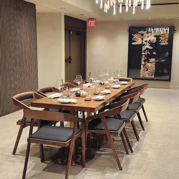 Elegant private dining room at Yume Sushi Bar with a long wooden table set for guests.