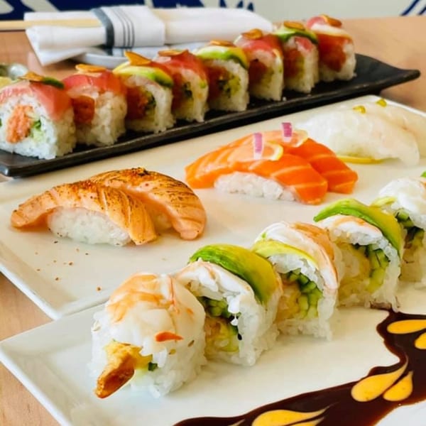 Plates of Yume Sushi Bar's sushi rolls, nigiri, and sashimi, including salmon and tuna.